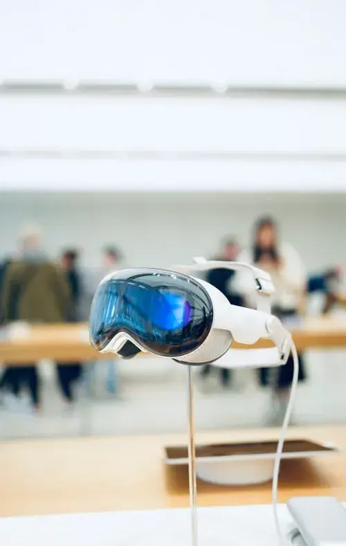 Apple Vision Pro mixed reality headset displayed on a stand, representing camera and AR integration capabilities.
